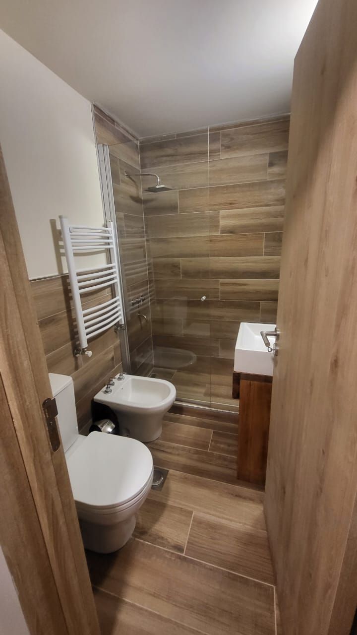 Ein kleines Badezimmer mit Dusche, Toilette und Waschbecken.
