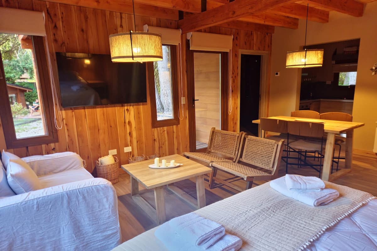 Een gezellige kamer met een bed, een bank, een tafel en een eethoek.