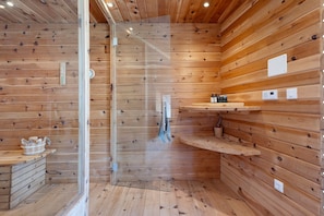 A wooden interior with a glass shower enclosure, wooden shelves, and a small wooden cabinet. - Apartment 'Felixdachl' with Mountain View, Shared Pool and Wi-Fi (Renon)