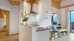 Una cocina moderna con una isla central, vigas de madera y vistas al exterior.