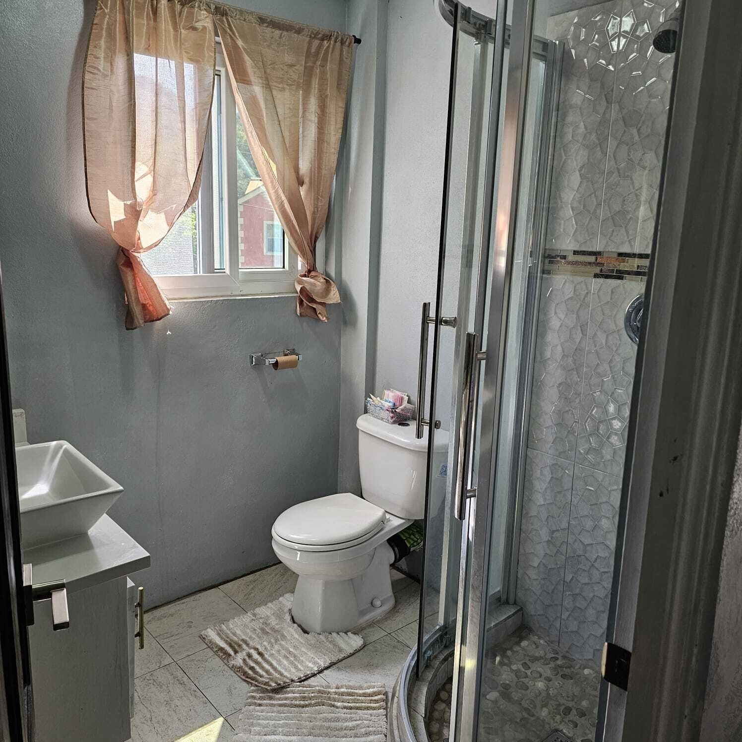 Een douche, handdoeken, zeep, toiletpapier