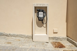 A portable electric charging station mounted on a wall with a stone pavement below. - Holiday Home 'Borgo Myricae - Viola Ciocca' with Mountain View, Wi-Fi and Air Conditioning (Chia)