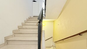 Eine Treppe mit Handlauf, einer Lampe und einer Wand mit kreisförmigem Dekor.