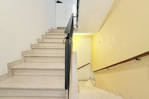 A staircase with a handrail, a light fixture, and a wall with a circular design. - P077 - Porto Recanati, spacious four-room apartment in the city center (Porto Recanati)