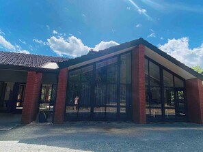 Un edifici amb una gran façana de vidre i pilars de maó.