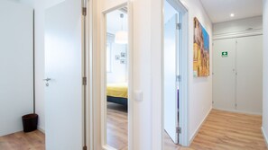 Ein Hotelgang mit einem Bett im Hintergrund, einem Bild an der Wand und einem grünen Notausgangsschild.