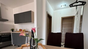 Un comedor con una mesa de madera, un jarrón con flores y una bandeja.