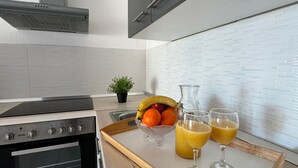 Una cocina moderna con horno integrado, campana extractora de acero inoxidable y encimera de madera.