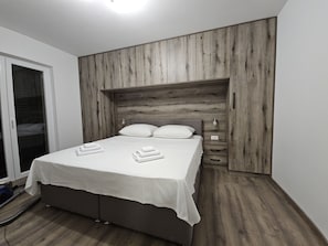 A bedroom with a wooden headboard, a bed with white linens, and a bedside table with a lamp. - Villa Pauliana in Povljana (Povljana)