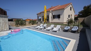 A swimming pool with lounge chairs and a yellow flag. - Villa Pauliana in Povljana (Povljana)