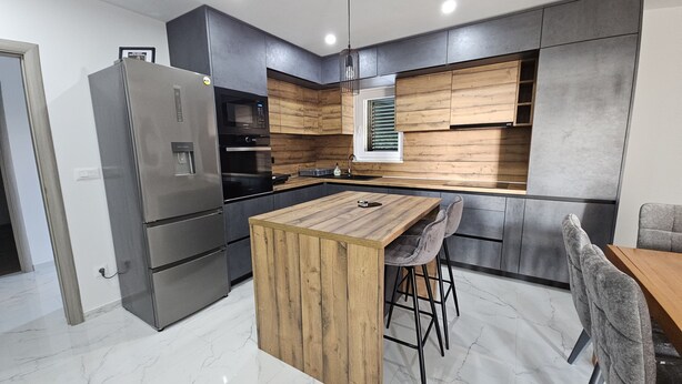 A modern kitchen with a central island, stainless steel appliances, and wooden cabinetry. - Villa Pauliana in Povljana (Povljana)