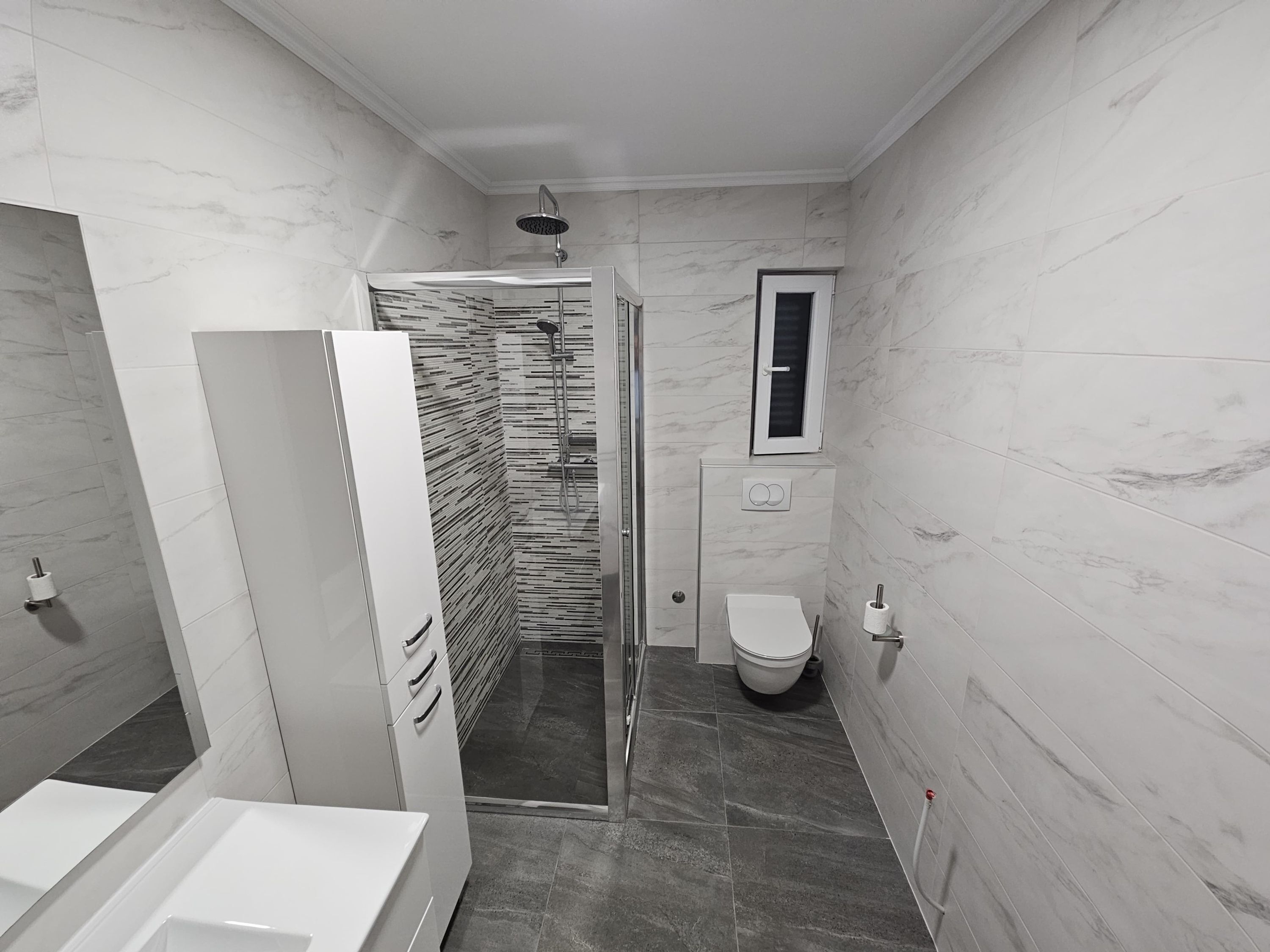 Ein modernes Badezimmer mit Dusche, Toilette und Waschbecken.