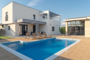 A modern two-story house with a swimming pool, outdoor seating, and a glass conservatory. - Beautiful Villa Aria (Zadar)