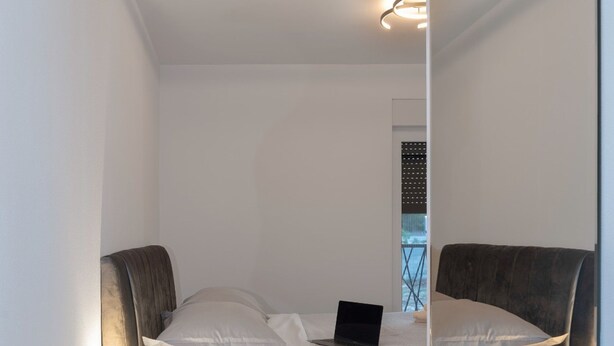 Une chambre à coucher moderne avec un lit, des tables de chevet et une commode.