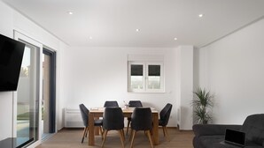 Un salon moderne comprenant un coin repas, un canapé et un téléviseur.