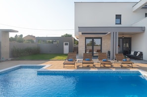 A modern pool area with lounge chairs and a clear view of the pool. - Beautiful Villa Aria (Zadar)