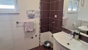 A bathroom with a white sink, a mirror, a towel rack, and a window with blinds. - Apartment Marcela in Zaton (Nin)