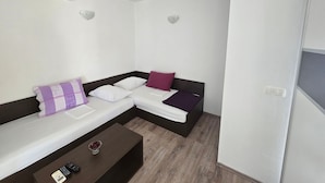 A modern room with a sectional sofa, a small table, and a wall-mounted air conditioner. - Apartment Marcela in Zaton (Nin)