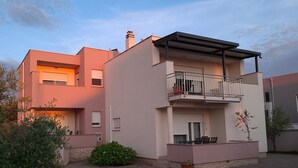 A modern two-story residential building with a balcony and a small garden area. - Apartment Marcela in Zaton (Nin)