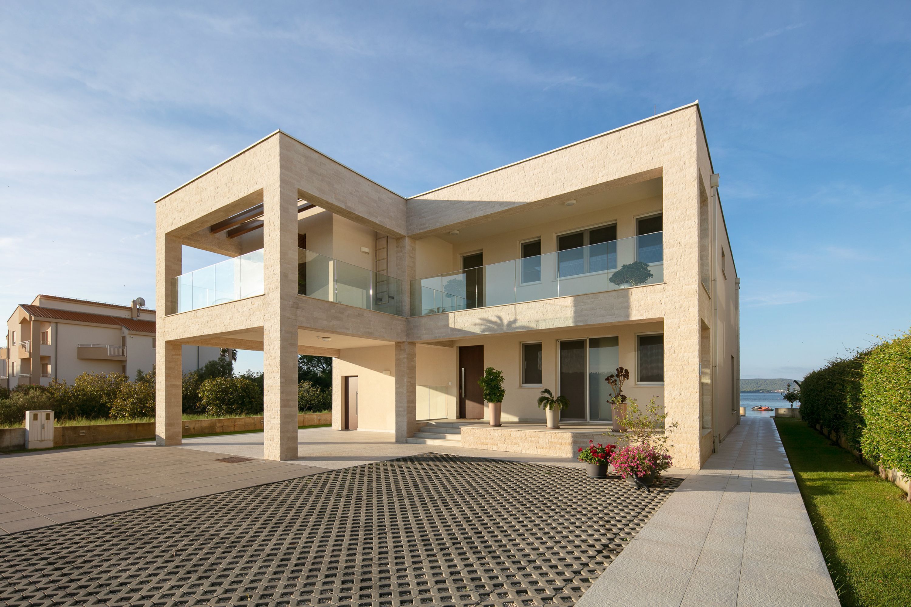 Un bâtiment moderne à deux étages, doté d’un toit plat, de grandes fenêtres et d’une cour dallée.