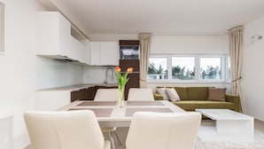 Um apartamento moderno com área de jantar, cozinha e sala de estar.