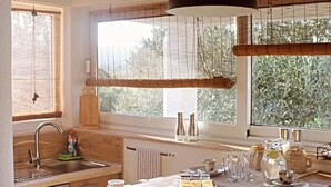 A kitchen with wooden beams, a large window, and a dining table set for tea. - Family Home Iskra in Bulic (Benkovac)