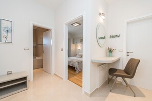 A modern hotel room with a bed, a vanity with a mirror, a chair, and a small desk. - Sargas Suite 4 With Garden View (Novalja)