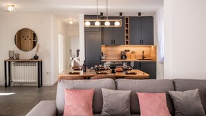 Un soggiorno moderno con un divano grigio e un'area pranzo con un tavolo in legno.