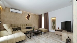 Una sala de estar moderna con un sofá modular, una mesa de centro, un televisor de pantalla plana y una decoración de estilo minimalista.
