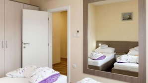 Een hotelkamer met een bed, een kast, een spiegel en een airconditioning.