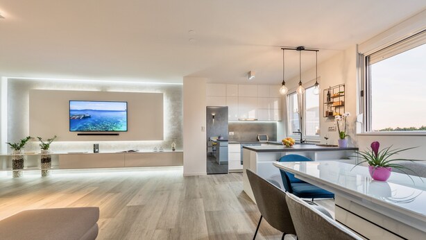 Una cucina moderna con una grande isola, elettrodomestici integrati e vista sul mare.