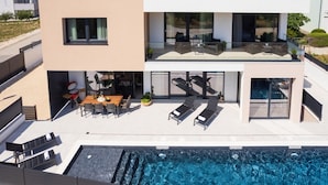 A modern two-story house with a swimming pool, outdoor seating, and a balcony. - Villa Santa With Heated Pool (Pakostane)