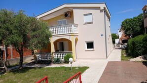 A two-story building with a balcony, a small window, and a number '72' sign. - Holiday Home Bella 1 Bella 2 (Povljana)