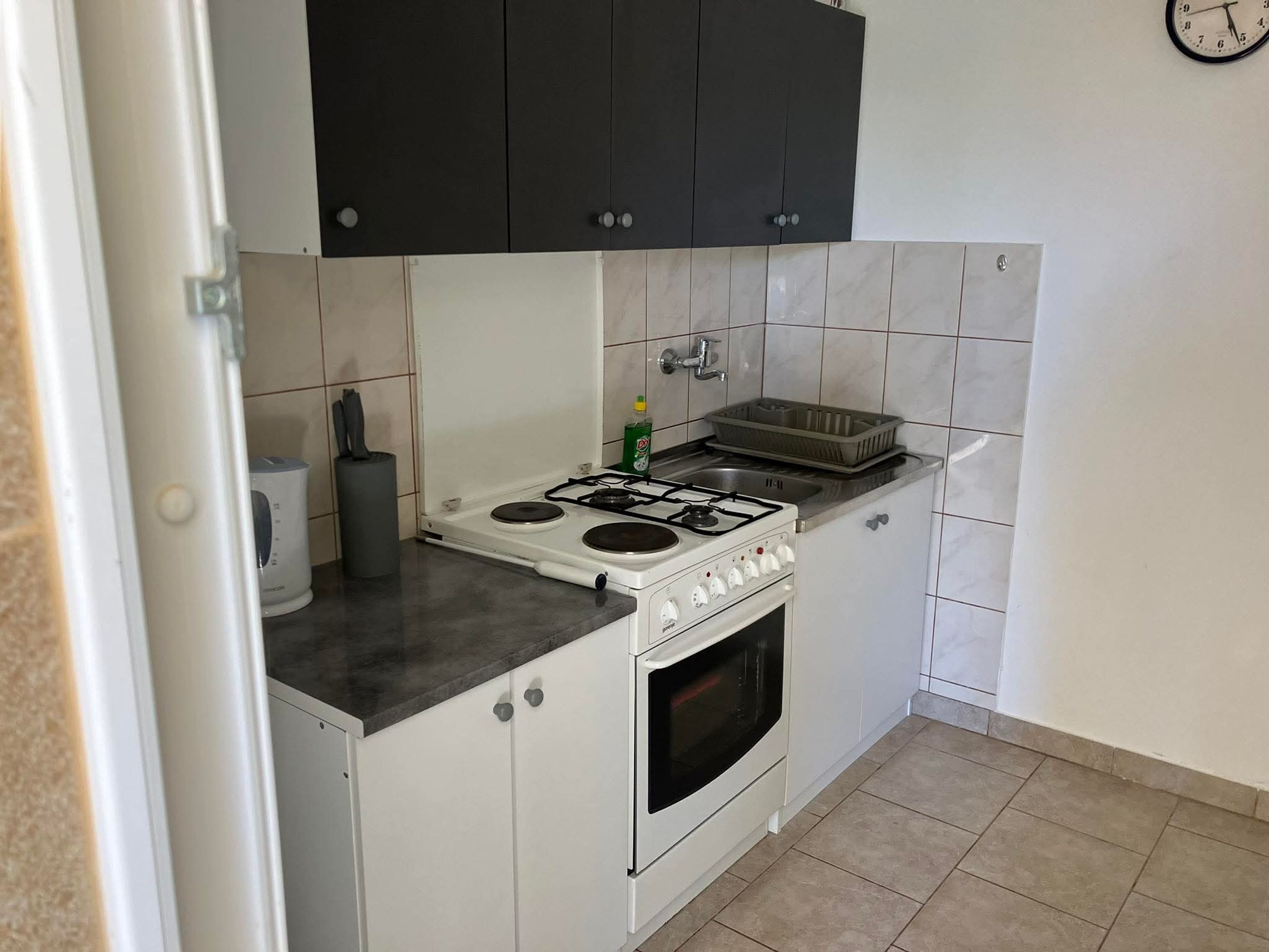 Cozinha compacta com fogão, forno e pia.