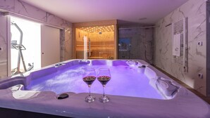 A modern spa room with a hot tub, two glasses of red wine, and a wooden interior. - Beachfront Villa Promenada (Posedarje)