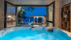A hot tub with a view of a wooden pergola and outdoor seating area. - Beachfront Villa Promenada (Posedarje)