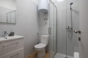 A modern bathroom with a toilet, sink, and glass-enclosed shower. - Holiday Home Lantina With Pool (Novigrad)