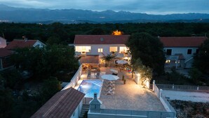A villa with a swimming pool, outdoor seating, and a mountain backdrop. - Holiday Home Lantina With Pool (Novigrad)