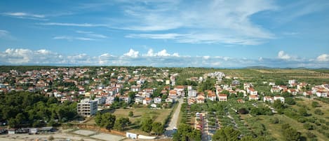 An aerial view of a coastal town with residential buildings, a marina, and a beach area.