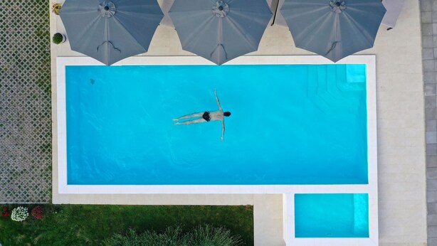 Ein rechteckiger Swimmingpool mit einer darin schwimmenden Person.