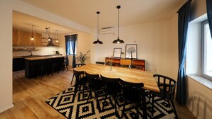 Eine moderne Küche mit Holzausstattung, einer zentralen Kochinsel und Pendelleuchten.