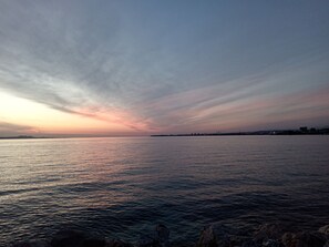 Een kustgezicht met rustig water en een verre kustlijn.
