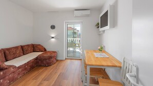 Een moderne woonkamer met een hoekbank, een houten eettafel en een witte radiator.