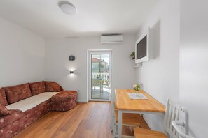 Ein modernes Wohnzimmer mit einer Eckcouch, einem Holzesstisch und einem weißen Heizkörper.