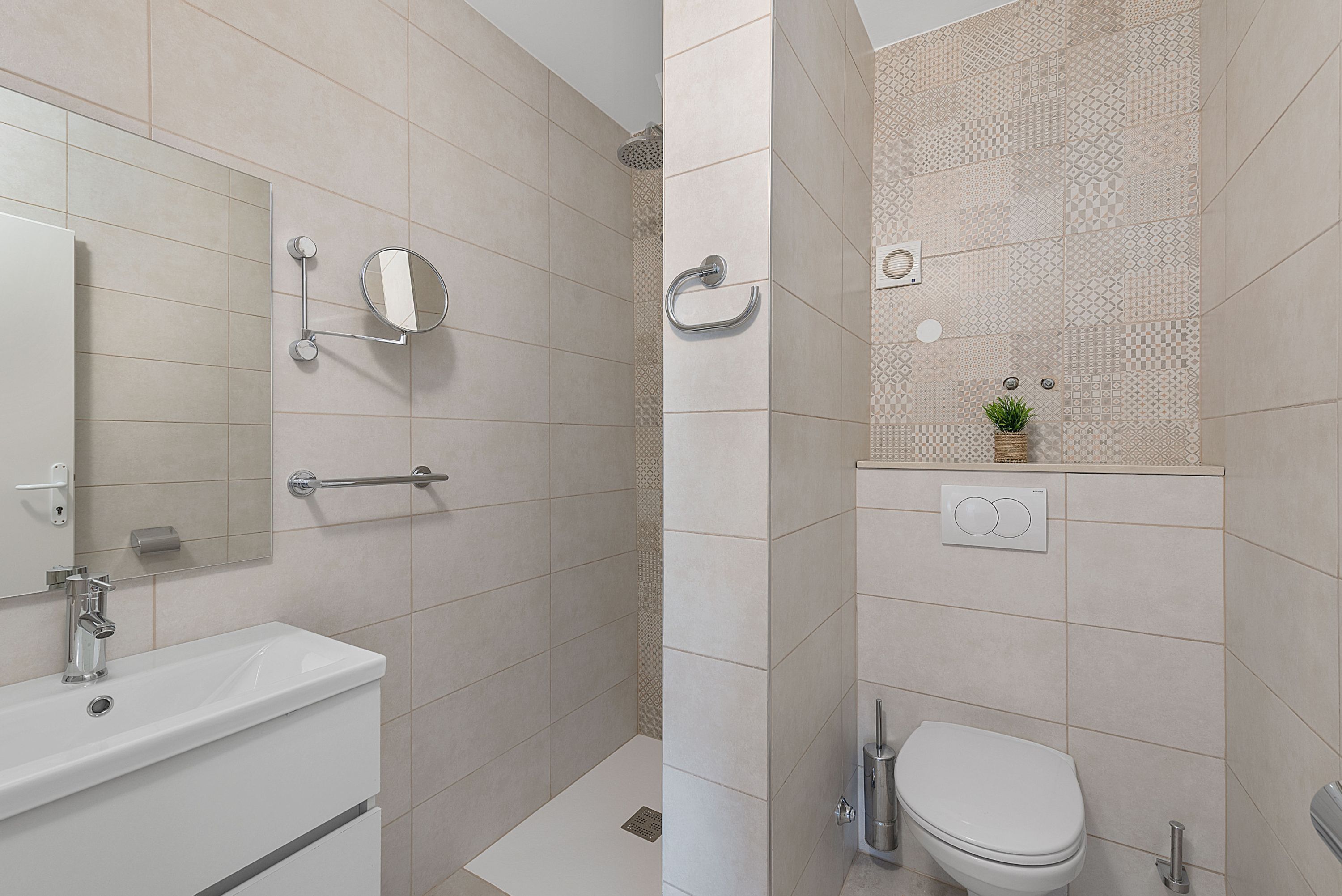 Un baño moderno con ducha, inodoro y lavamanos.