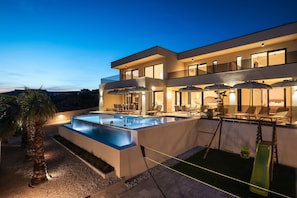 A modern two-story house with a swimming pool, outdoor seating, and a slide. - Luxury Villa Nuova With Heated Pool (Jasenice)