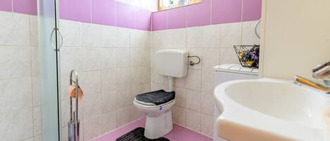 A bathroom with a toilet, bidet, and sink.