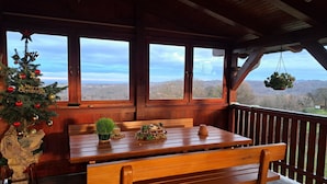 A wooden deck with a bench and table, overlooking a scenic landscape. - Holiday Home Ventura (Varazdinske Toplice)