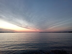 Une étendue d'eau calme, avec une rive lointaine et un ciel dégagé.