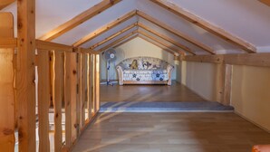 An attic room with wooden beams, a patterned sofa, and a fan. - Oldtown Apartment Apola 2 (Bibinje)
